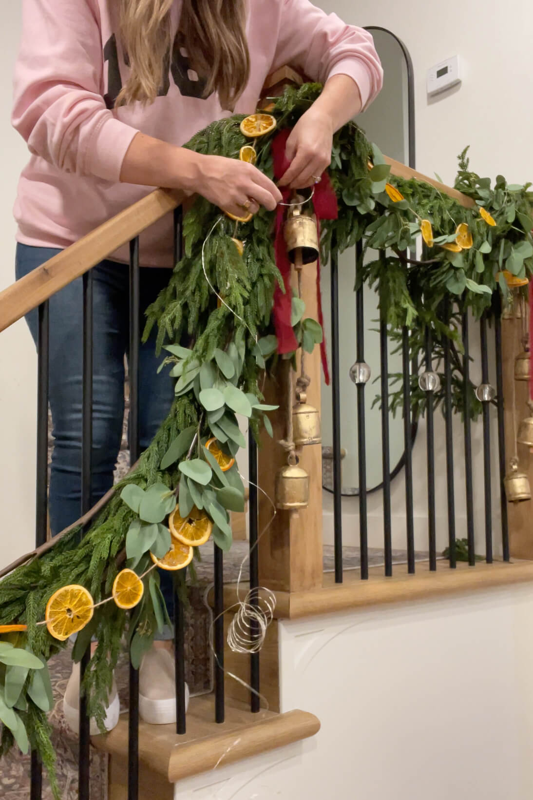 Adding a bow to my Christmas staircase decor.